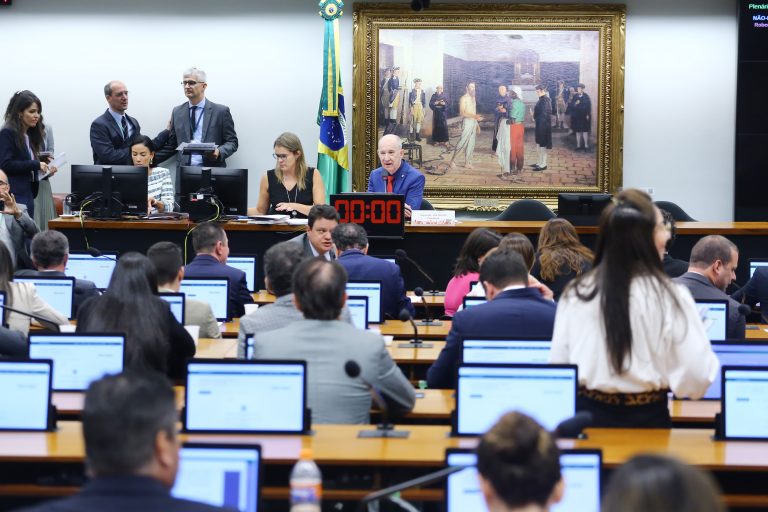 Deputados estão sentados num plenário