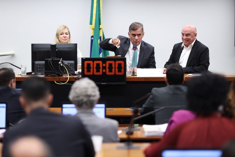 Deputados estão sentados num plenário