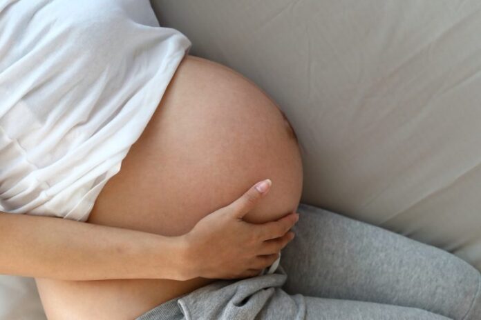 A barriga de uma grávida de perfil