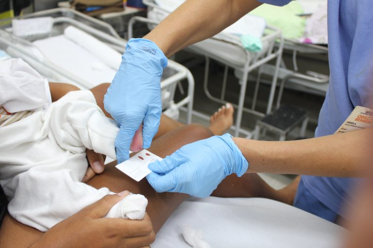Enfermeira faz o teste do pezinho em um bebê